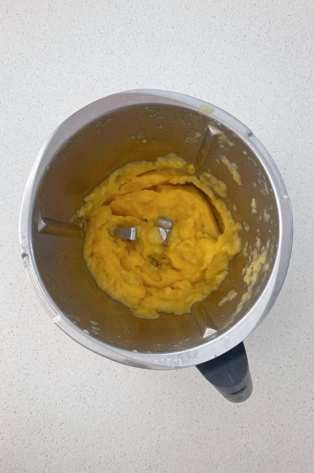 Blended mango pieces in a Thermomix bowl.