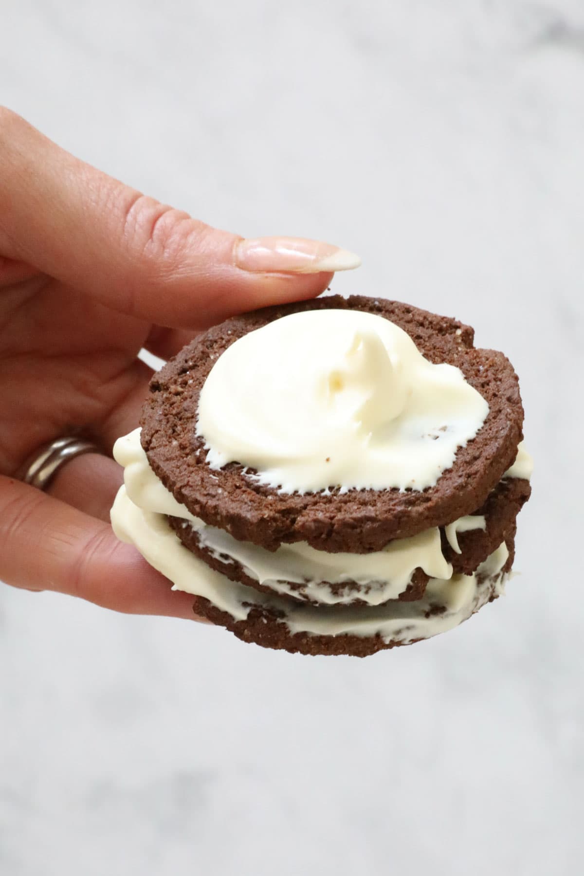 A stack of choc ripple biscuits and whipped cream.