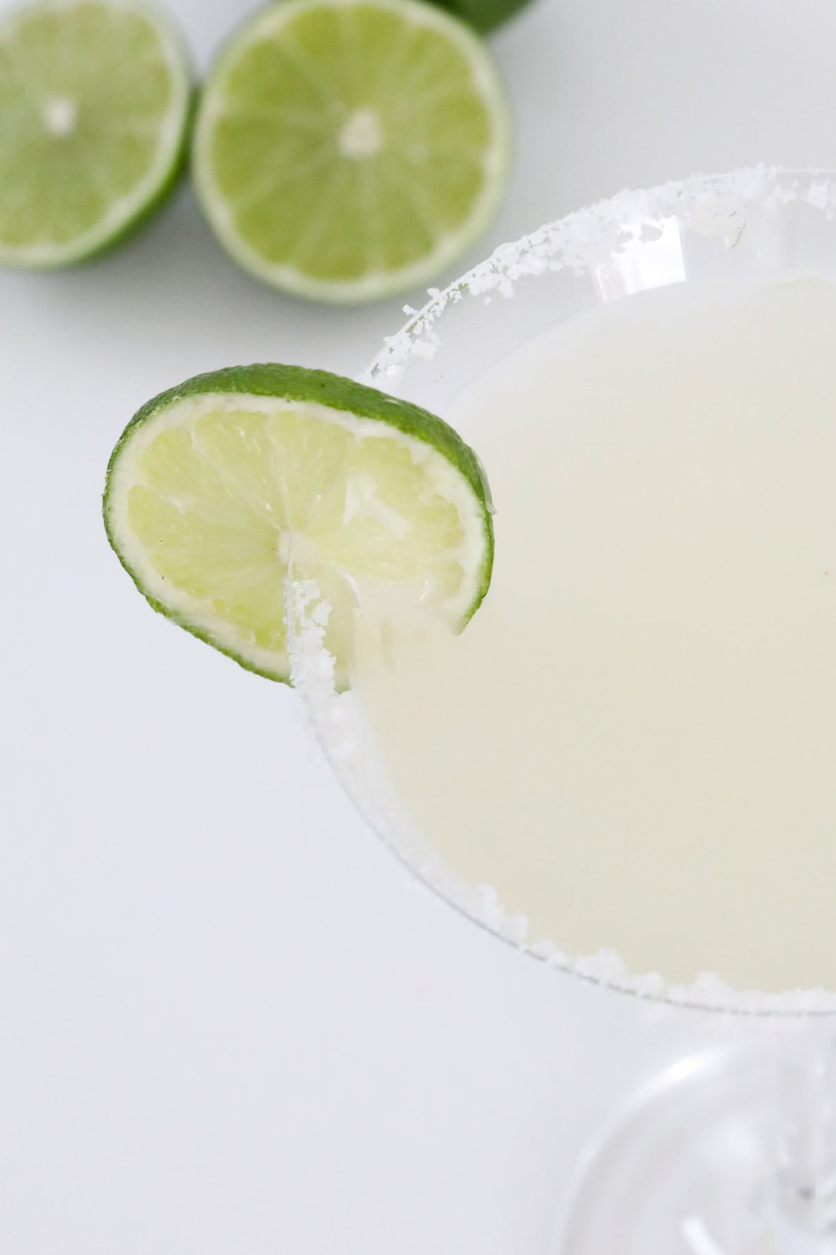 An overhead shot of a martini glass with lime and salt.