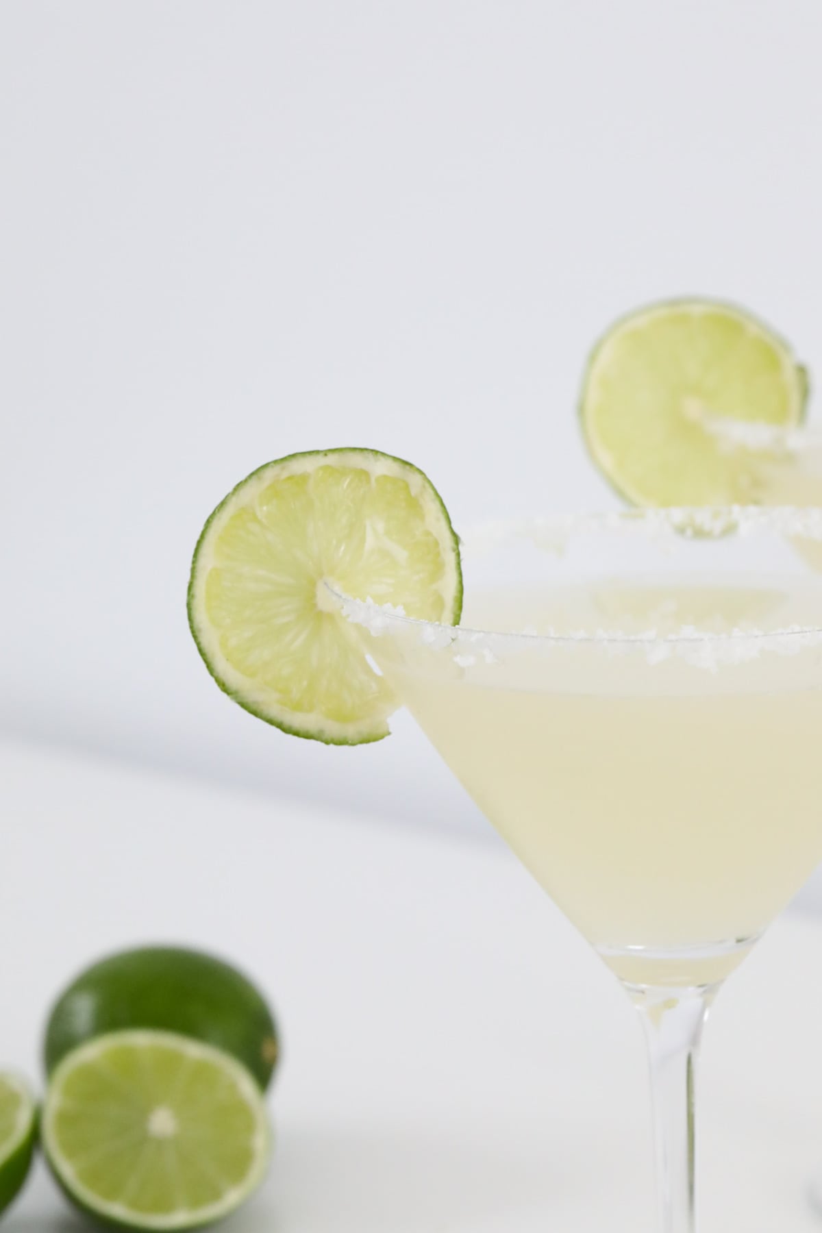 Lime and salt garnishing a cocktail glass with margarita.