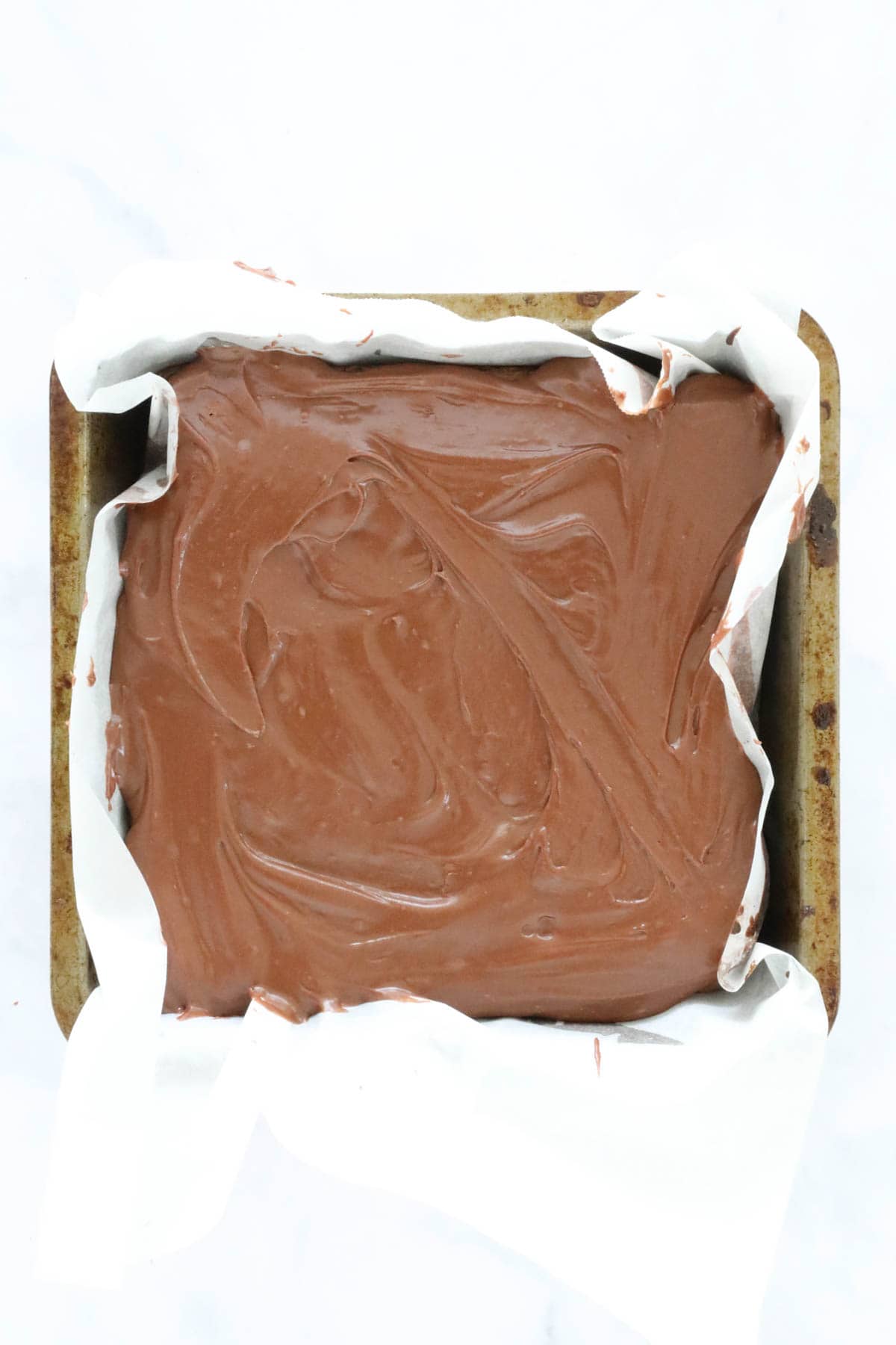 A frosted brownie in a tin.