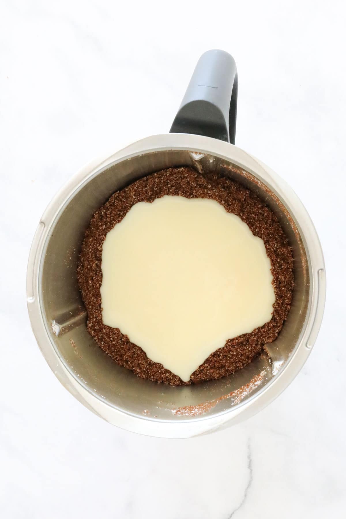 Chocolate mixture and sweetened condensed milk in a Thermomix.