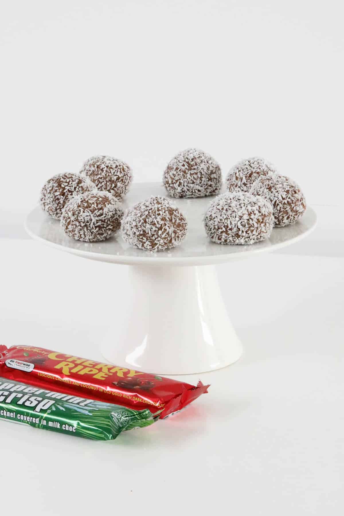 A cake stand topped with chocolate coconut balls.