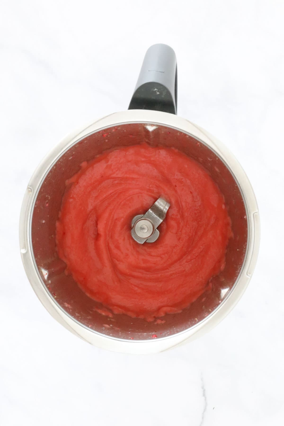 A Thermomix bowl filled with a strawberry cocktail.