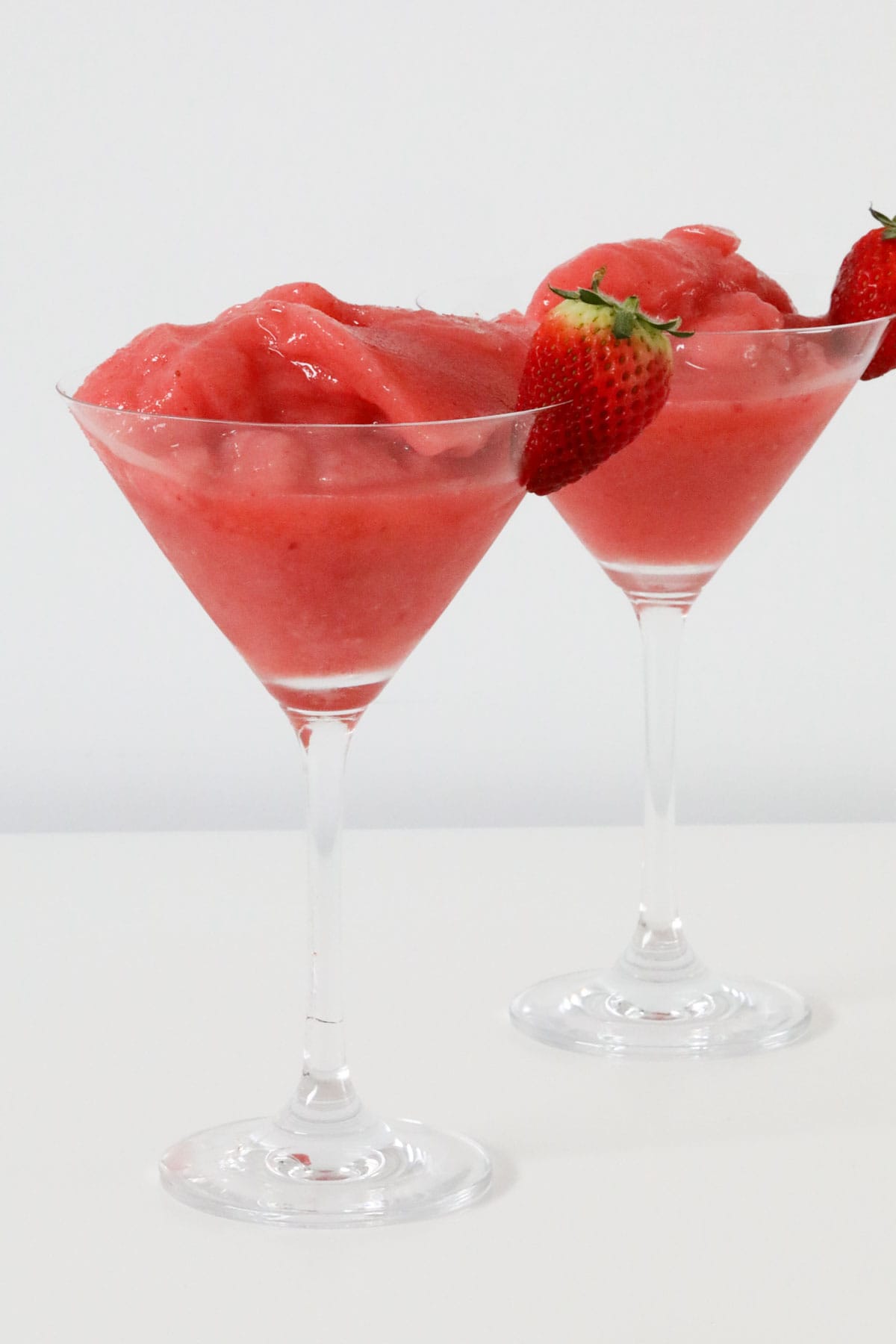 Two glasses of frozen strawberry daiquiri.