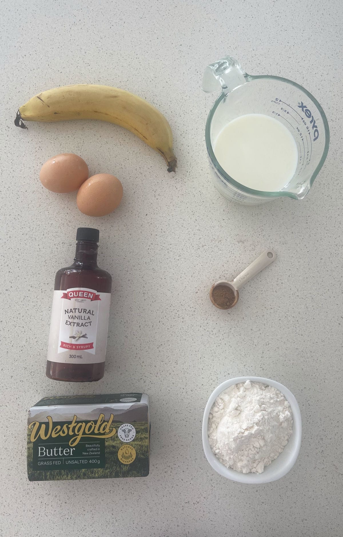 Ingredients to make Banana Pancakes in a Thermomix on a speckled bench.