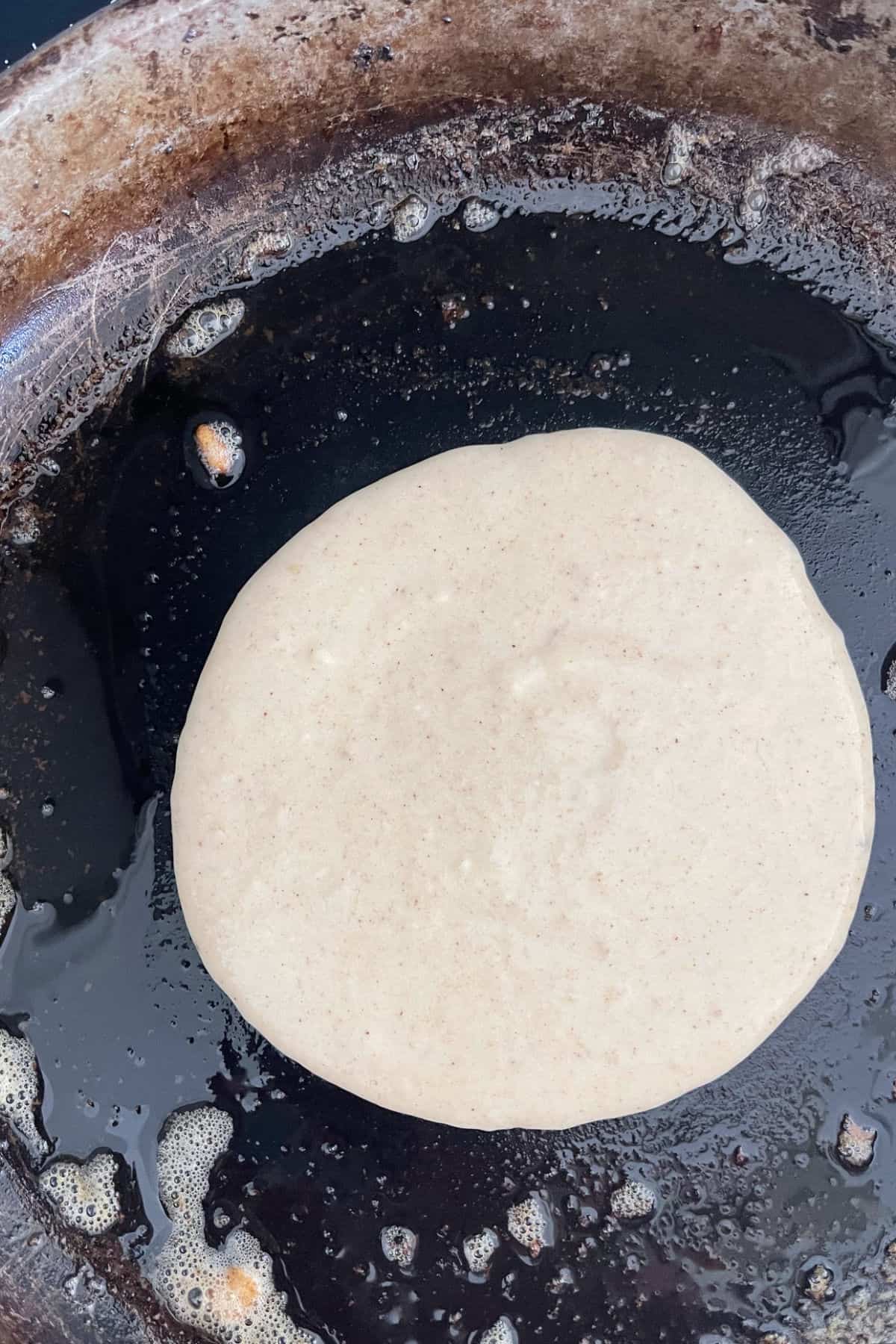 Banana Pancake mixture in a cast iron frying pan.