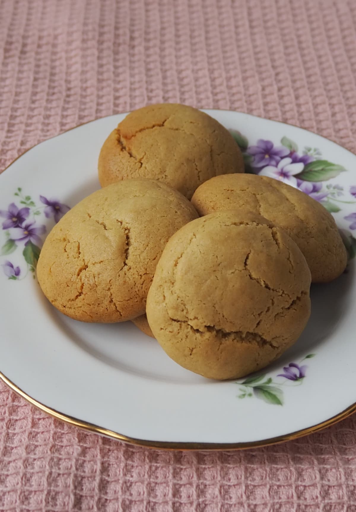 Four Caramel Cookies sitting on a decorative plate with gold edging.