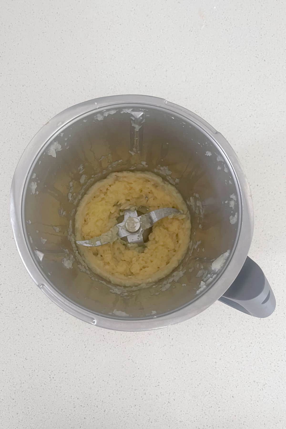 Cooked onion in a Thermomix bowl.