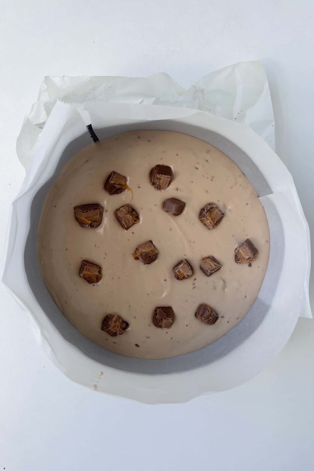 No bake mars bar cheesecake in a springform tin ready to be put into the fridge.