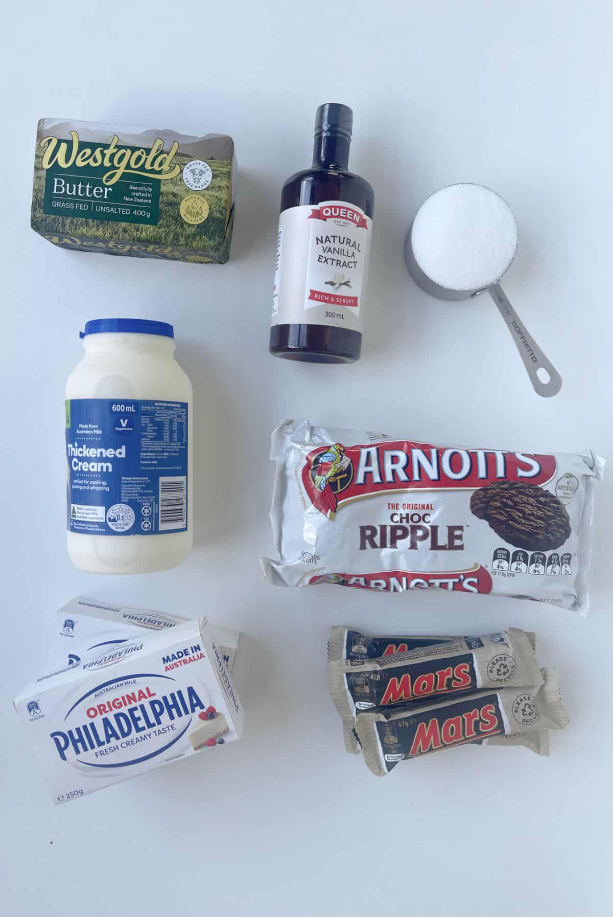 Ingredients to make Thermomix Mars Bar Cheesecake on a speckled bench top.