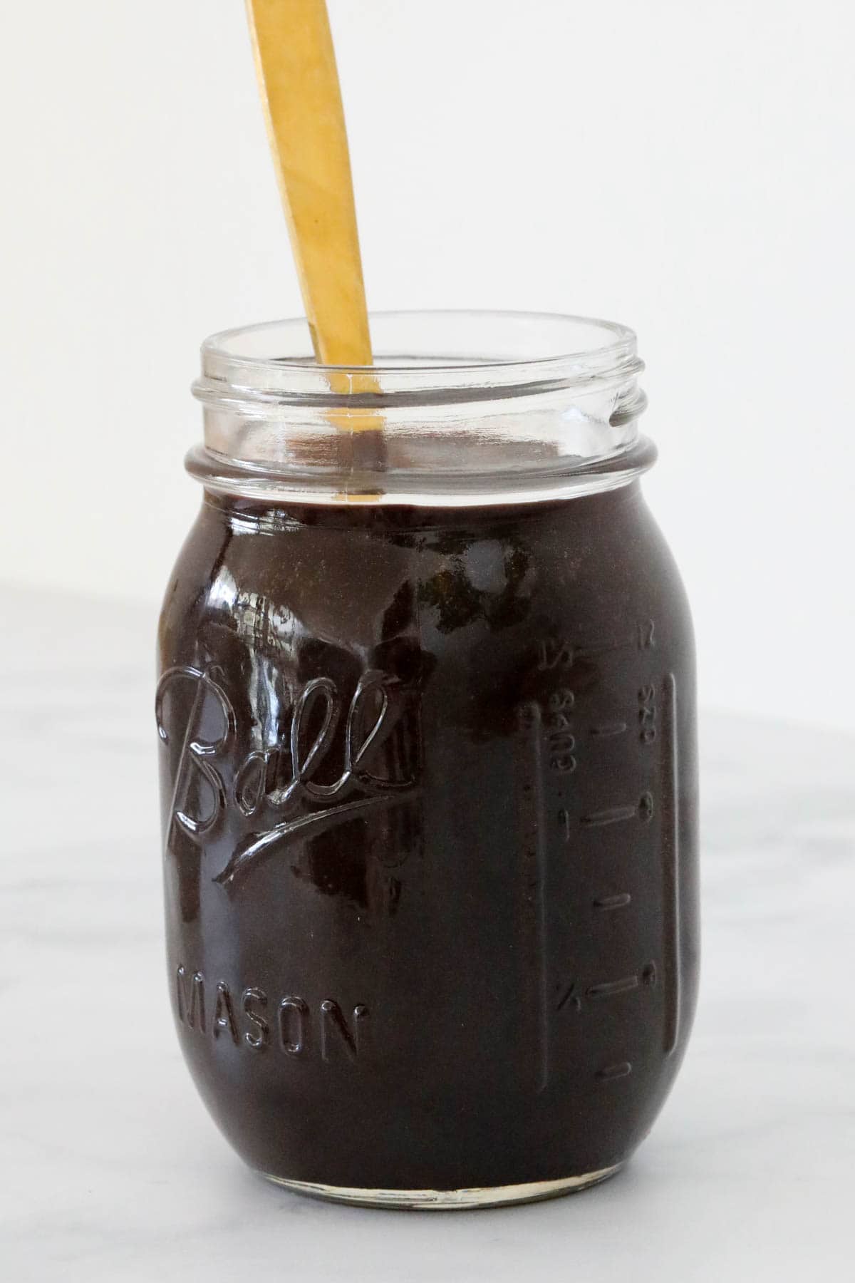 A glass jar of fudge sauce.