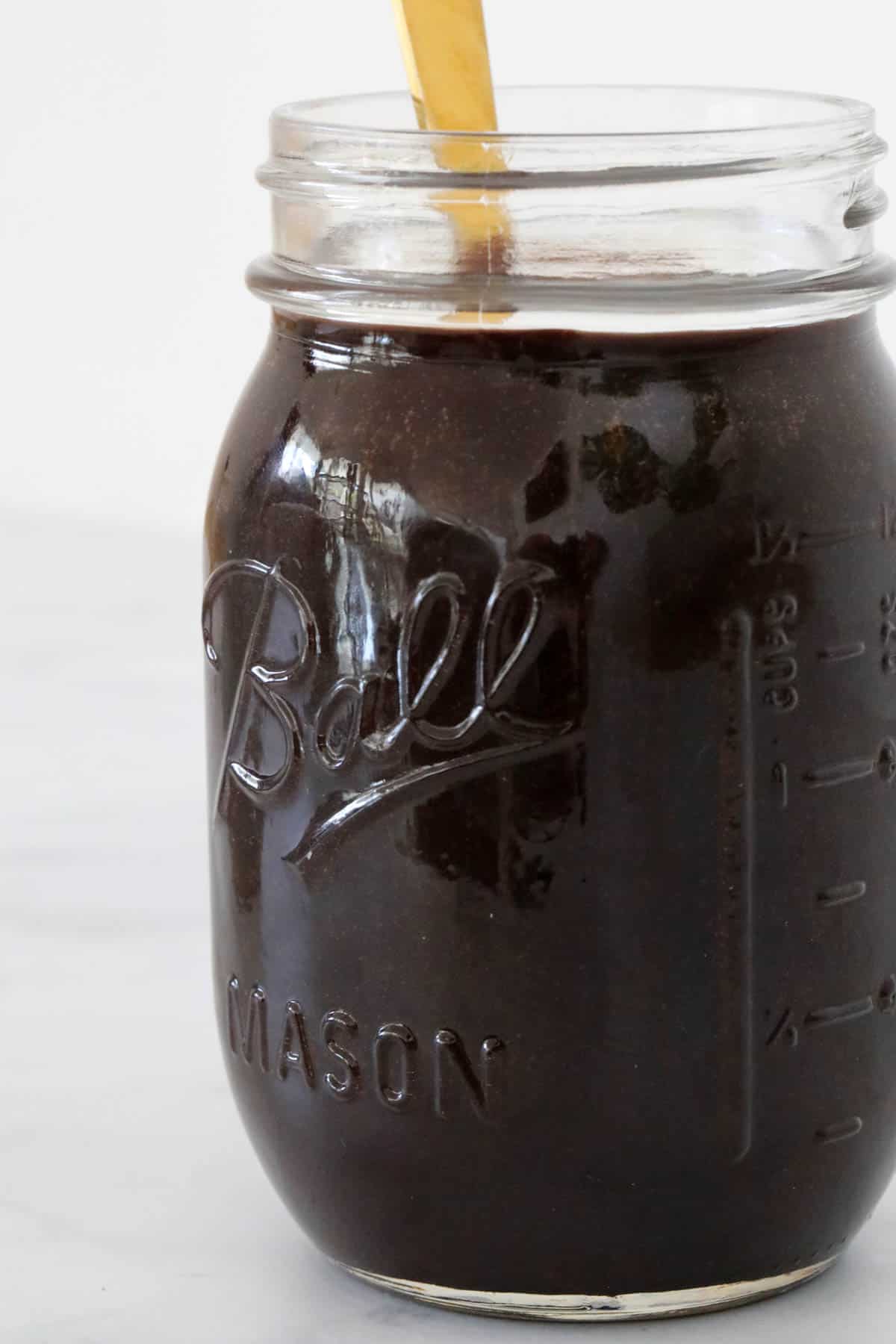 A glass jar of fudge sauce.