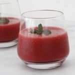 A glass of raspberry drink with mint.