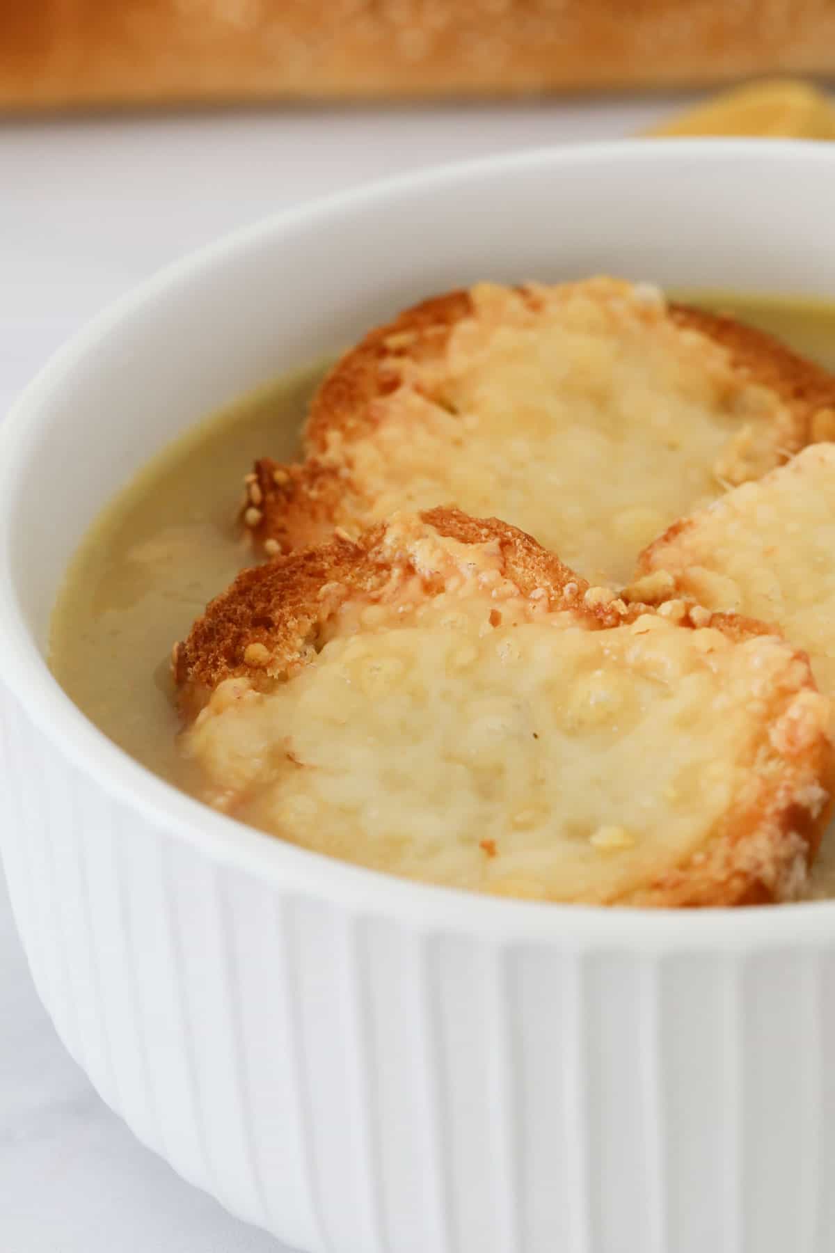 Melted cheese baguettes on top of onion soup.