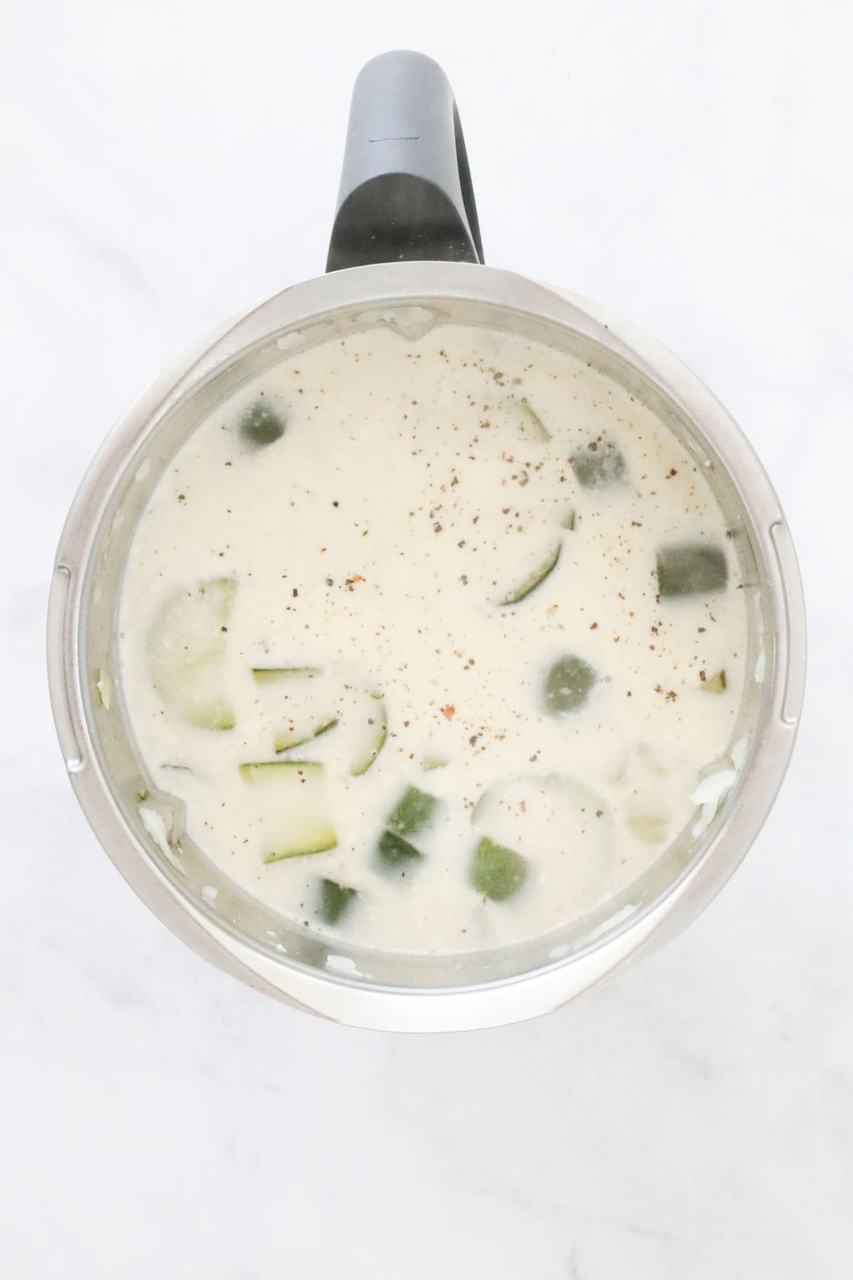 Creamy mixture with zucchini in a Thermomix bowl.
