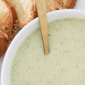 A spoon in a bowl of creamy zucchini soup.