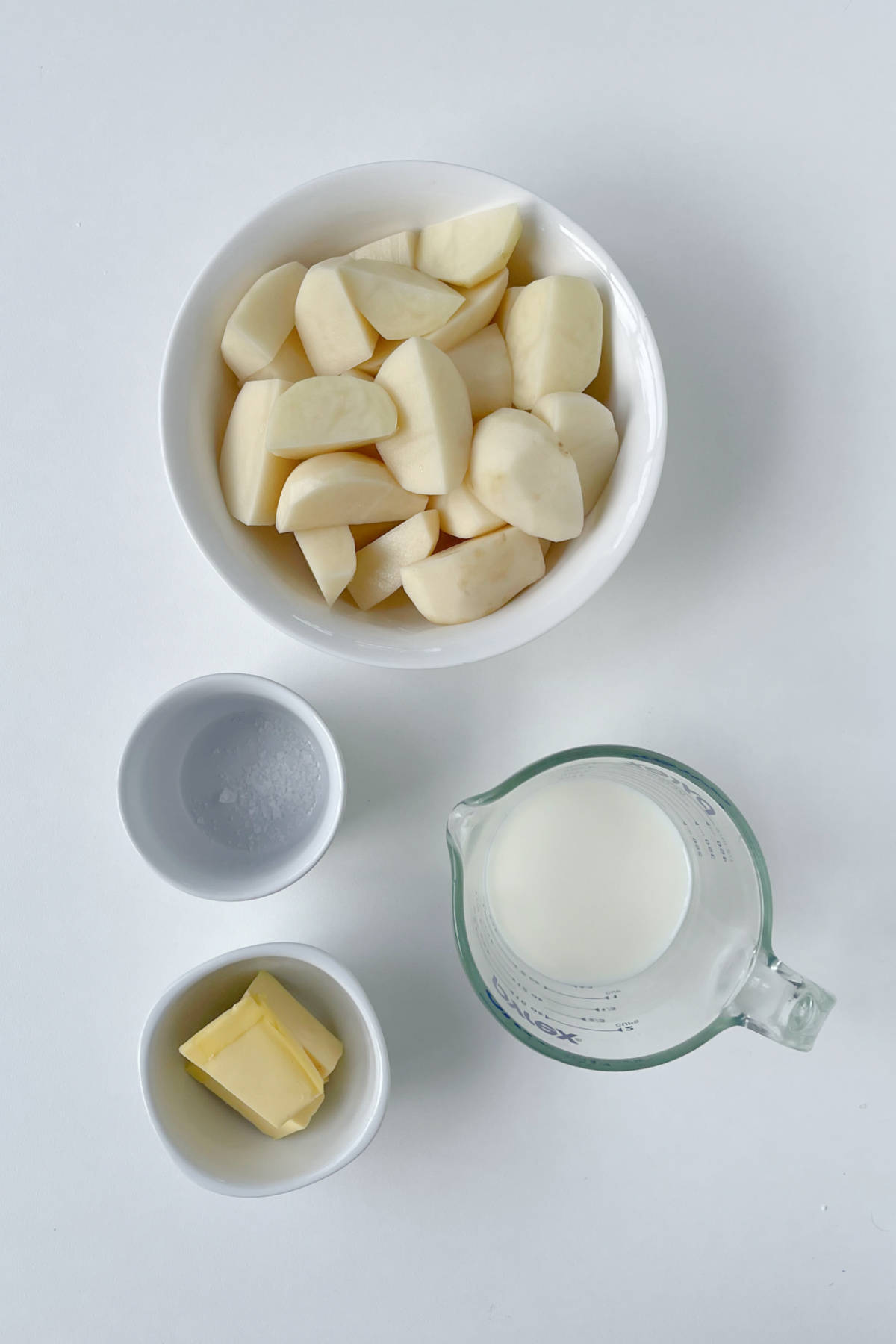 Ingredients to make mashed potatoes in a thermomix on a white bench top.