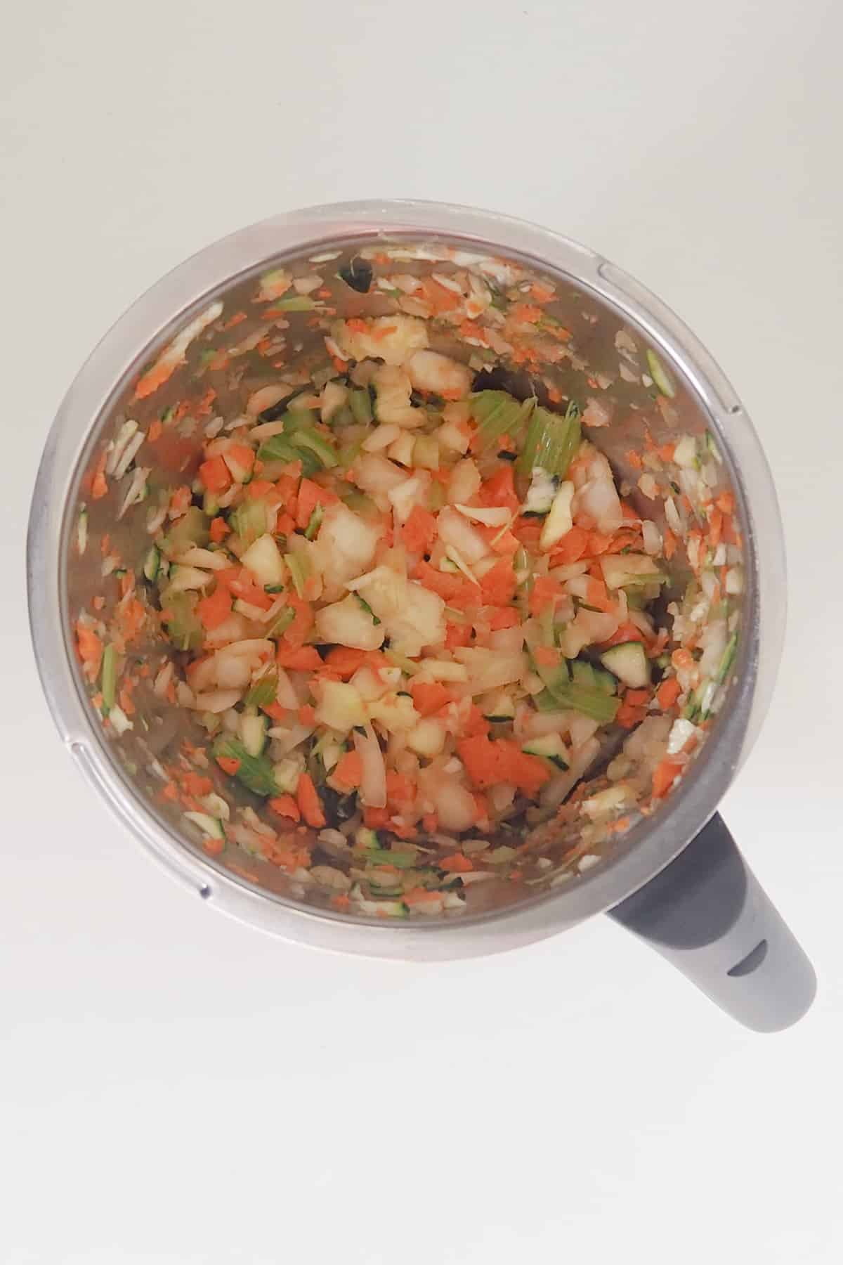 Chopped vegetables in a thermomix bowl.