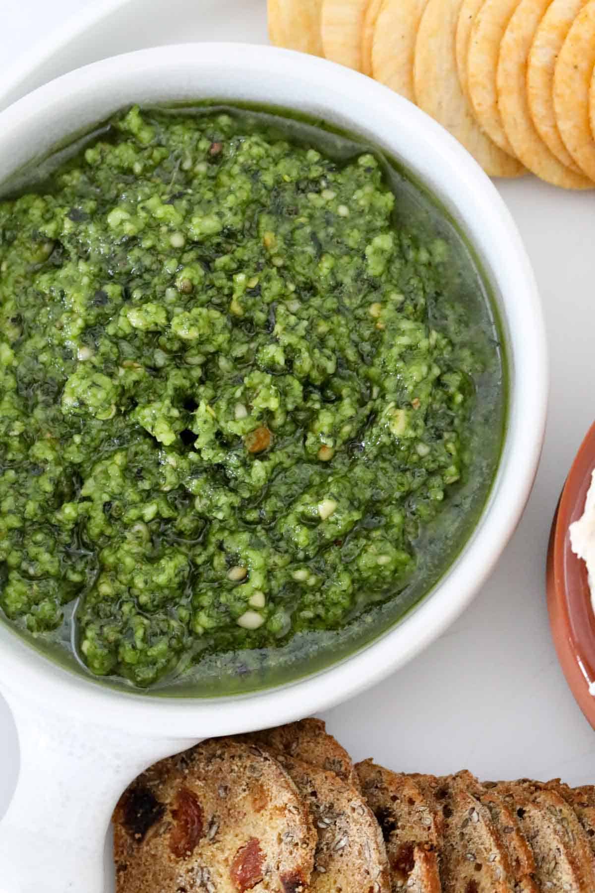 An overhead shot of a bowl of basil pesto.