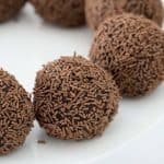 Rum balls coated in chocolate sprinkles on a plate.