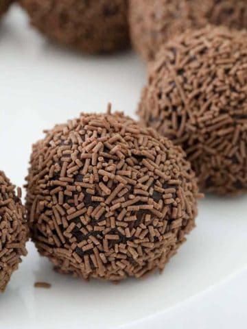 Rum balls coated in chocolate sprinkles on a plate.