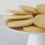 Round shortbread biscuits on a white cake stand.