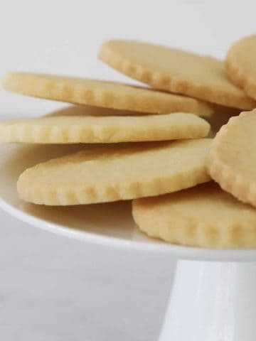 Round shortbread biscuits on a white cake stand.