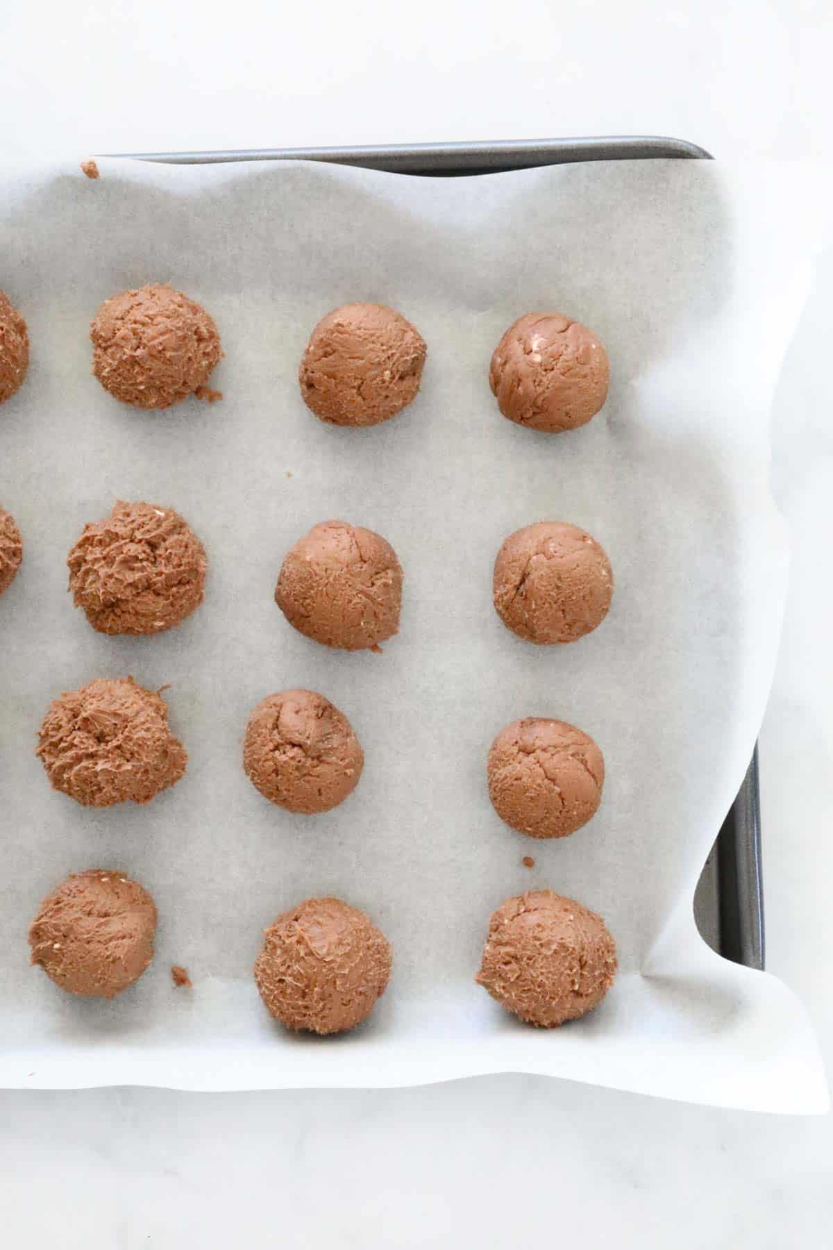 Chocolate cheesecake balls on a tray.