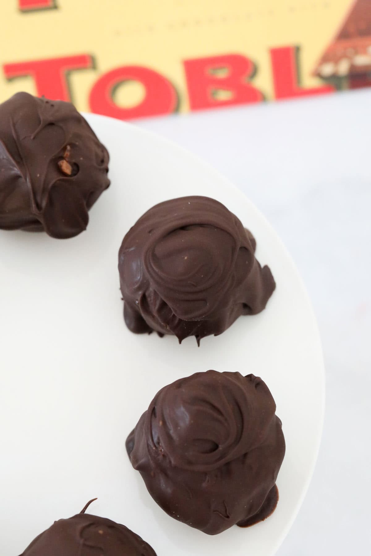A bar of Toblerone chocolate behind chocolate balls.