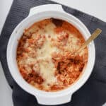 Cooked Pasta bake with a couple of scoops removed, a gold spoon is sticking out to the side.