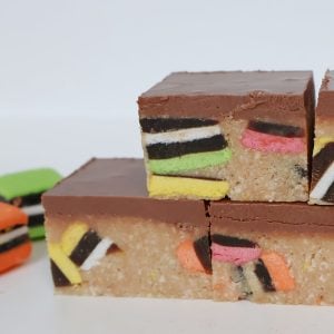 three pieces of Licorice Assort Slice stacked. Licorice all sort pieces next to it.