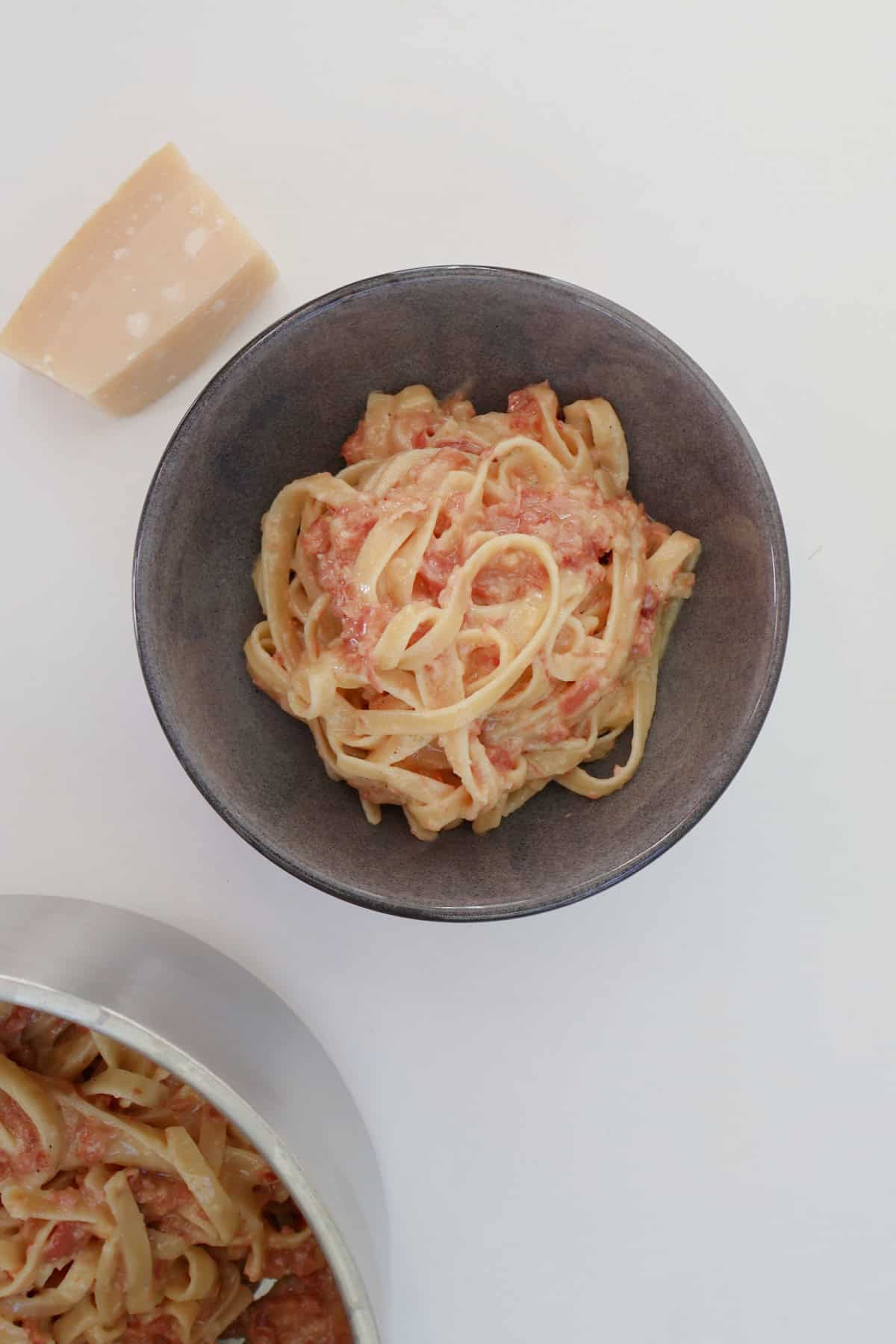 Overhead view of Carbonara pasta in a grey bowl.