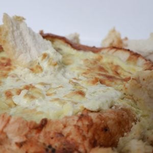 Close up of THermomix Bacon and Cheese Cob Loaf, piece of bread sticking out the top.