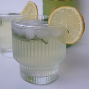 Side view of Limoncello Spritz garnished with a slice of lemon.