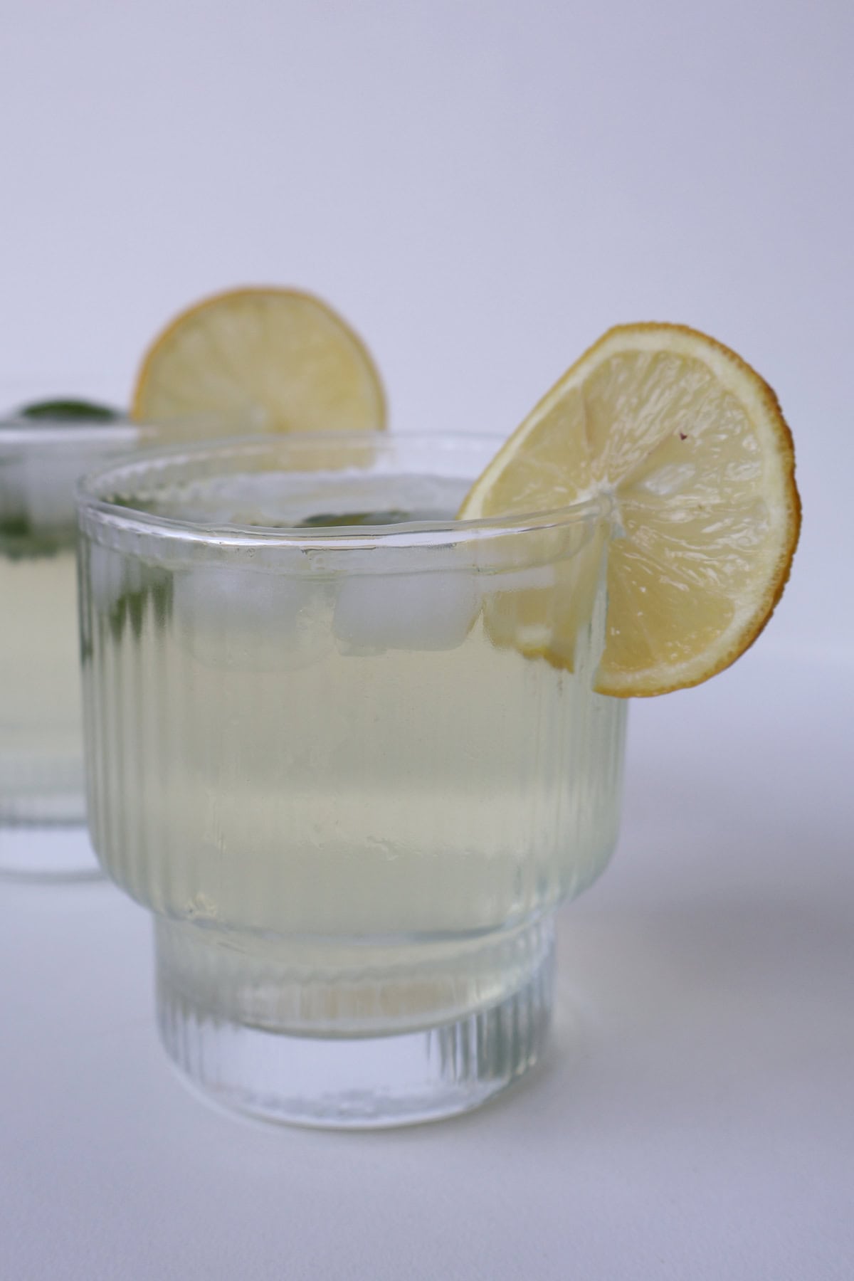 Side view of Limoncello Spritz garnished with a slice of lemon.