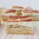 front view of Slices of Apple and Sour Cream Slice sitting on a pink striped plate.