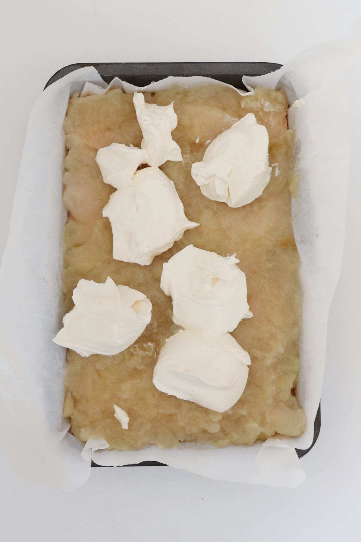 Dollops of sour cream over apple slice.