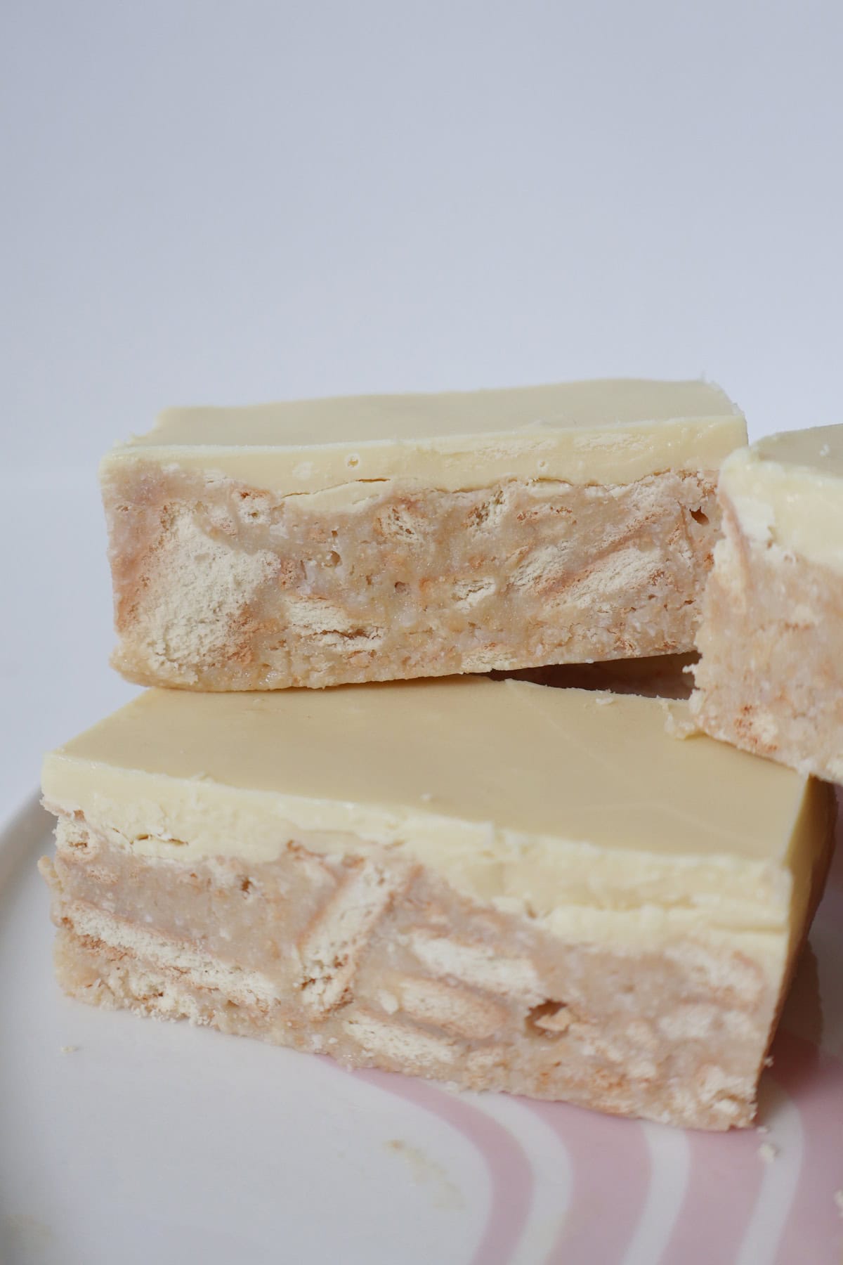 Slices of Thermomix White Chocolate Hedgehog Slice stacked on top of each other.